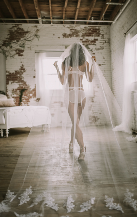 Bride from behind in veil in loft studio