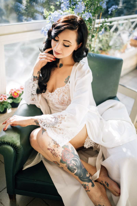 Bride in white lace robe in green velvet chair