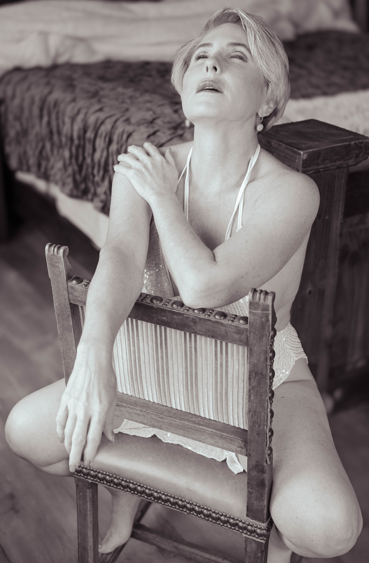 Black and white portrait of woman with antique chair